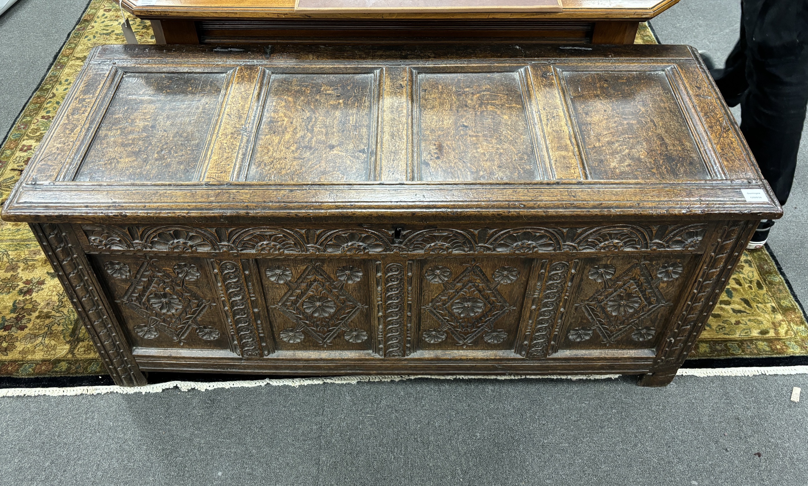 A late 17th century carved oak coffer, the front with four lozenge and rosette panels, beneath a lunette frieze, width 142cm, depth 56cm, height 64cm